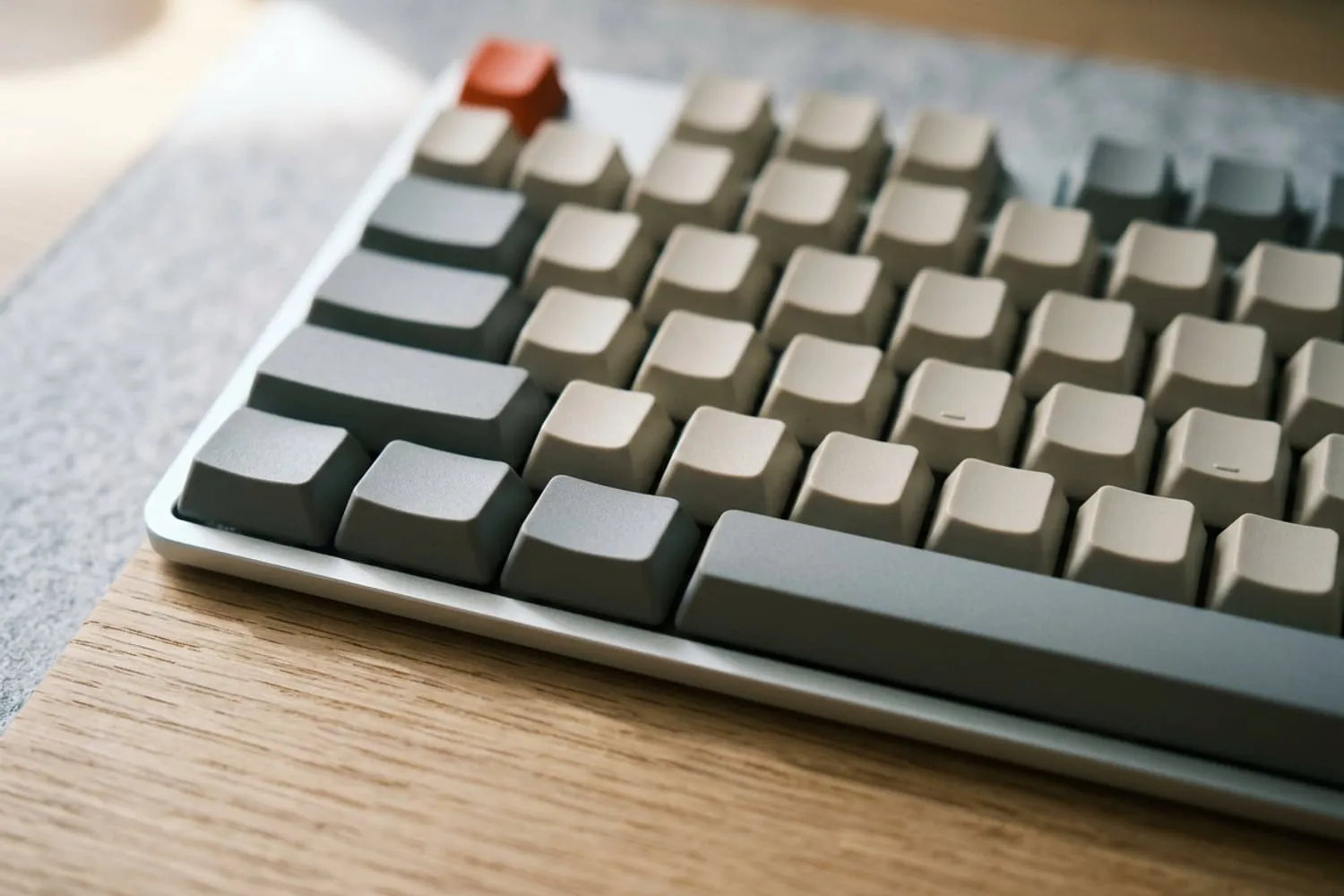 The left end of a space bar and the two wide keys beside it, very close up on a slim silver keyboard, every keycap blank, the rest of the keys softly out of focus